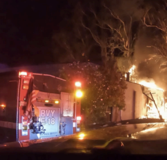 fire truck at night with blaze in the background